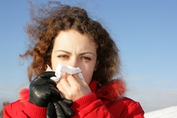 person holding tissue up to nose