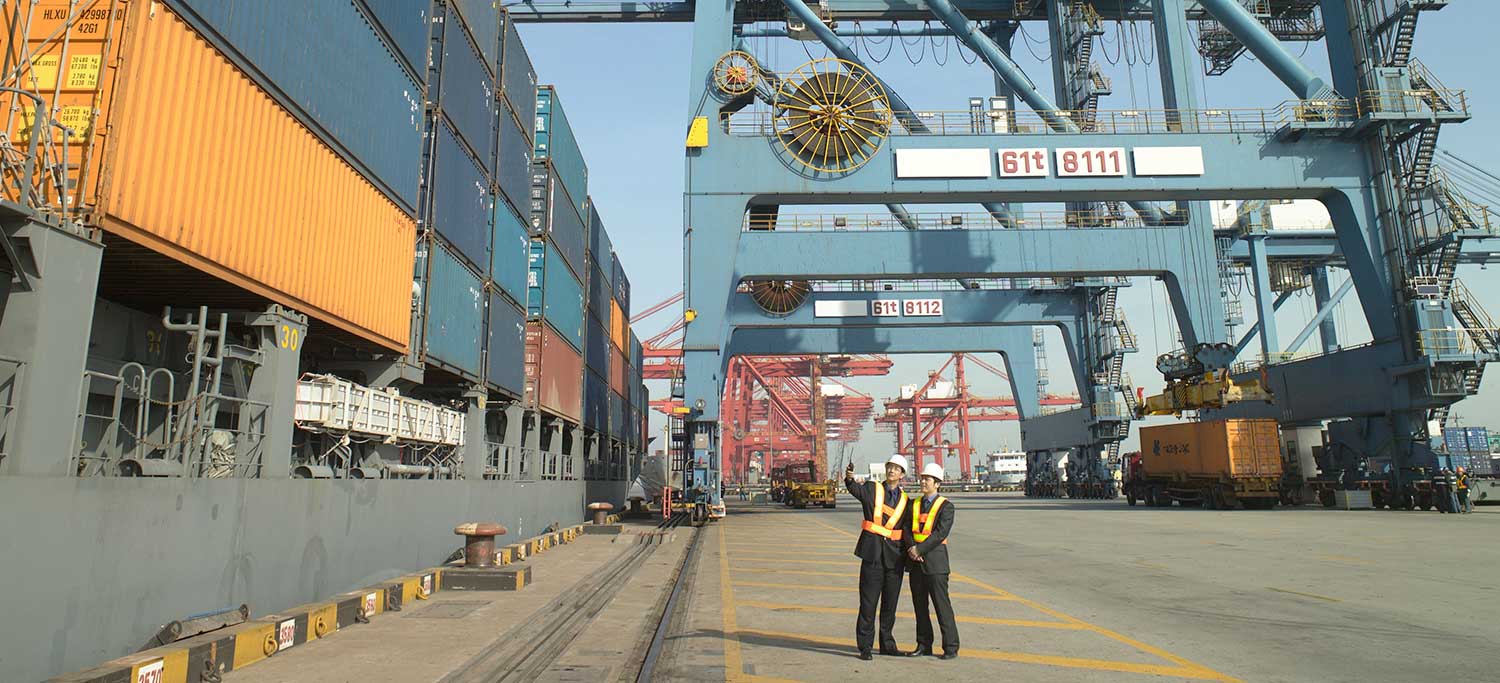 People inspecting shipping containers at a port