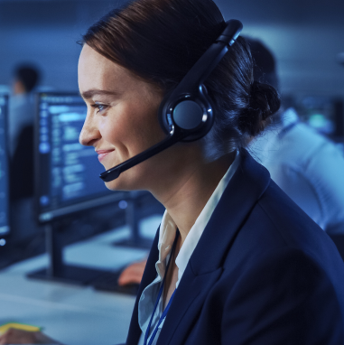 A woman wearing a headset looking at a computer