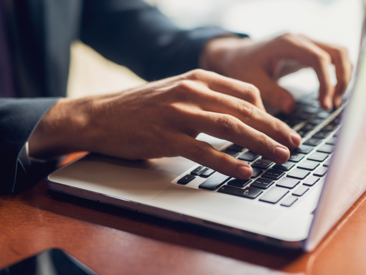 Shows hands typing on a computer