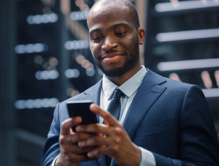 Shows a man looking at his mobile phone