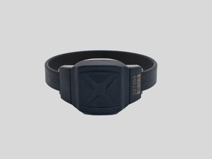Shows a small black bracelet monitoring device
