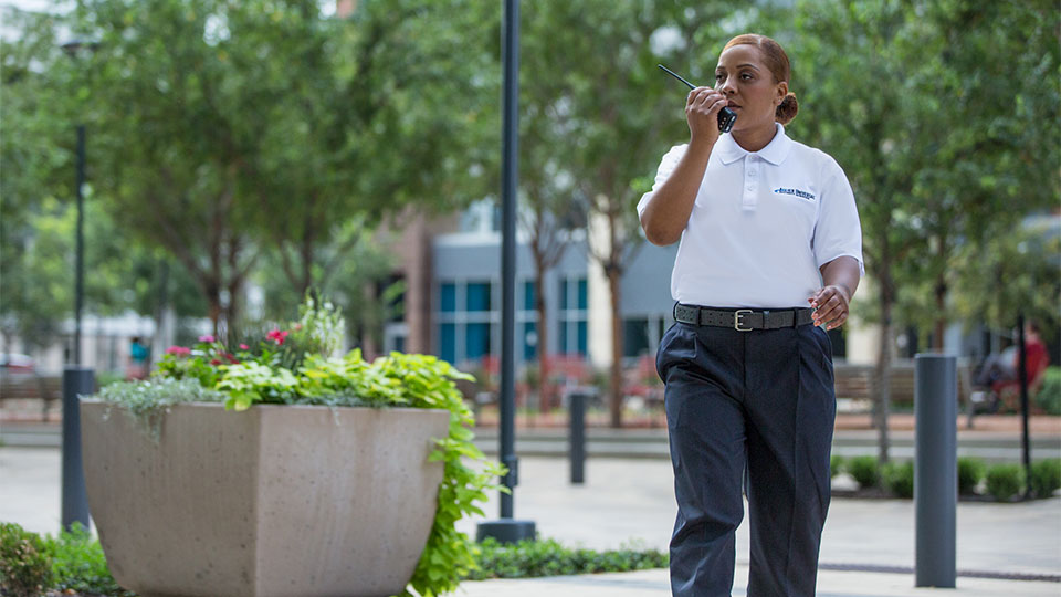 Security officer walking with walkie talkie