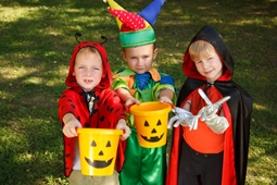 kids standing in halloween costumes