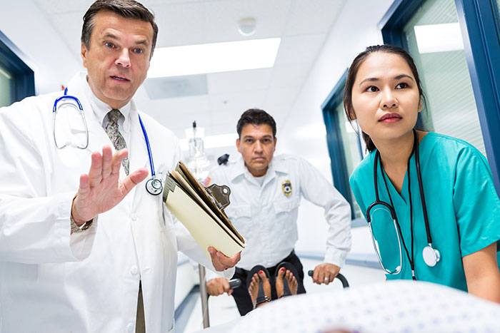 Medical professionals wheeling patient in hospital