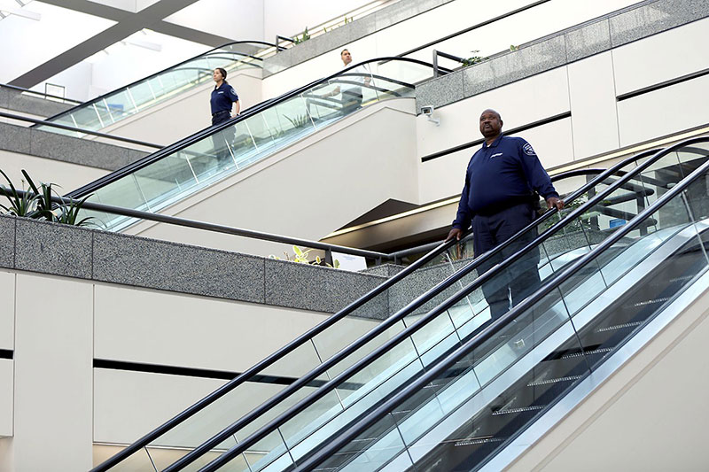 Allied Universal Security Officers going down escalators - escalator safety