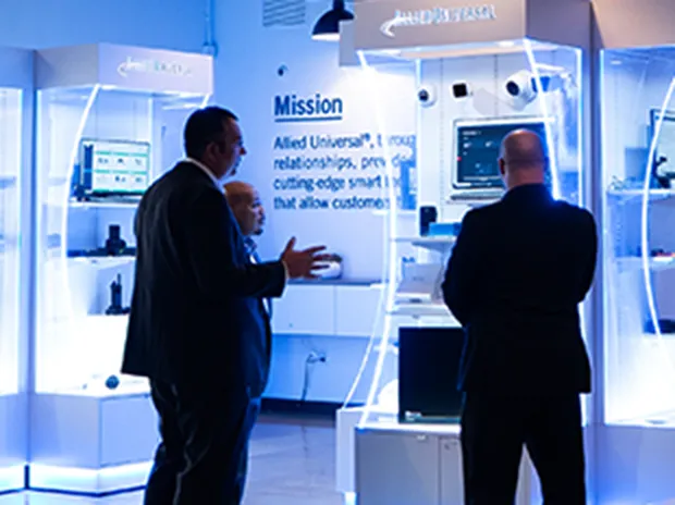 three men looking at a display case